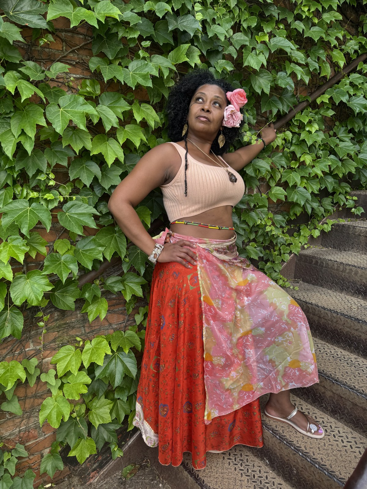 Ms. Sophia standing among green vines