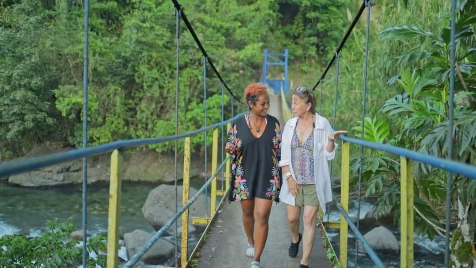 Two retreat participants walking together across a bridge in Jamaica
