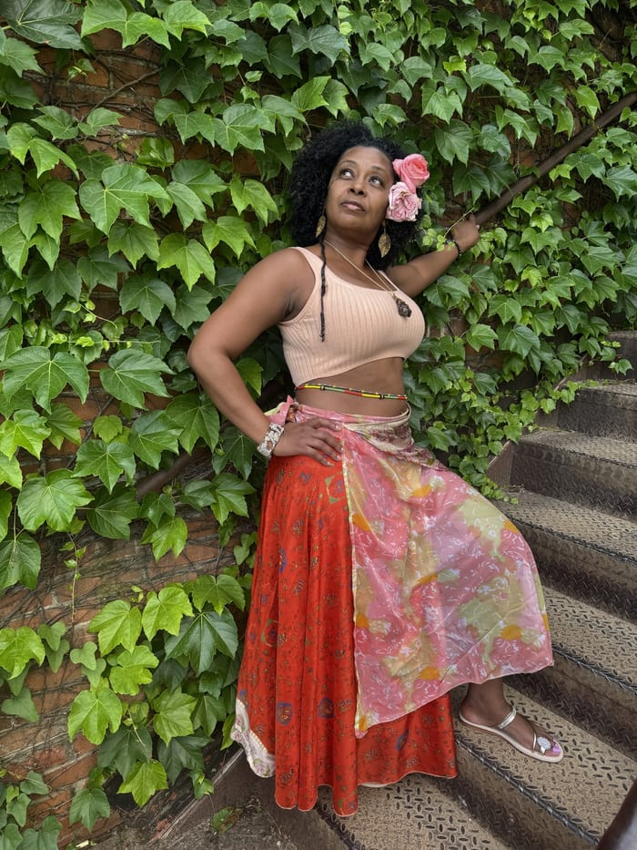 Ms. Sophia standing among green vines